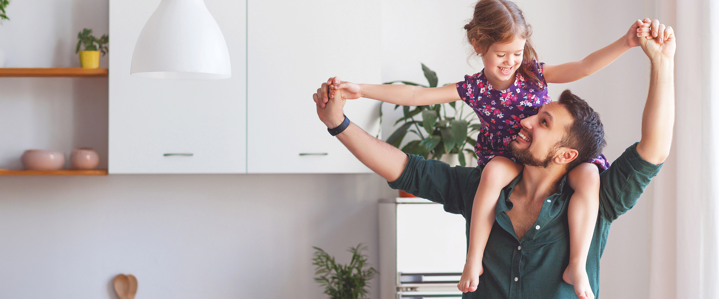 Photo of dad hoisting his daughter up over his shoulders.